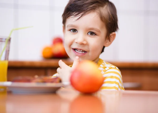 Little boy with glass of orange juice — Stock Photo, Image