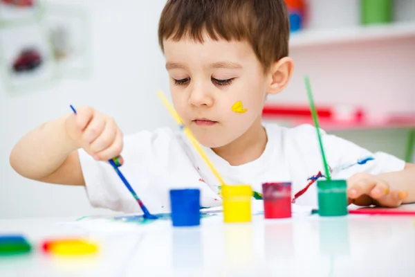 小さな男の子は塗料で遊んでいます。 — ストック写真