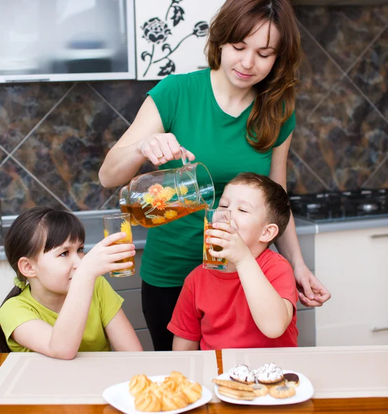 Moeder met kinderen drinken sap — Stockfoto