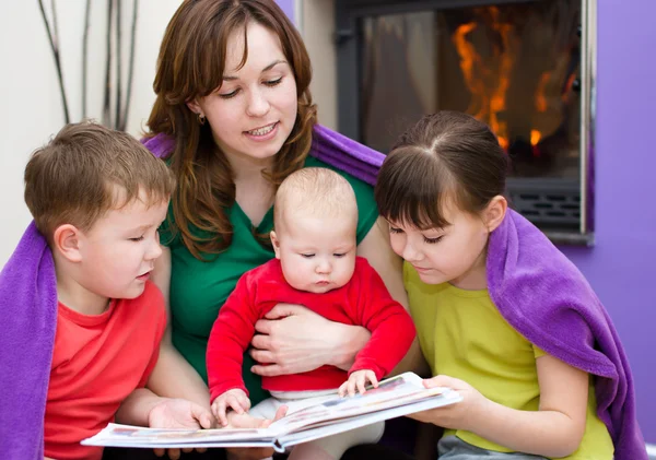 Moeder is het lezen van boek met kinderen — Stockfoto