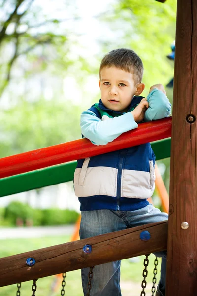 Kleine jongen speelt op speelplaats — Stockfoto