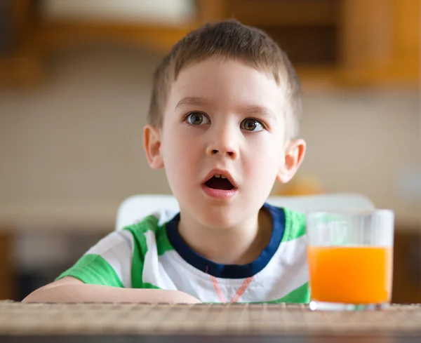 Liten pojke med glas apelsinjuice — Stockfoto