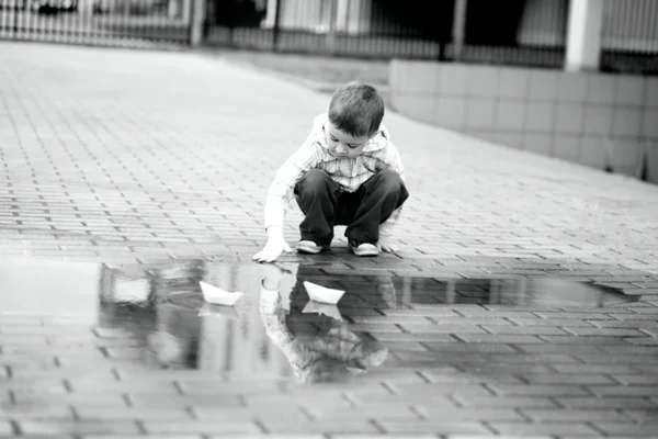 Boy is playing with paper boat — Stock Photo, Image