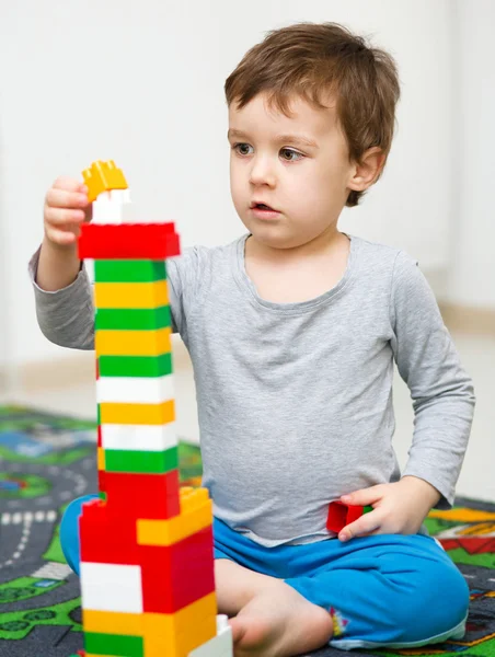Chico está jugando con bloques de construcción — Foto de Stock