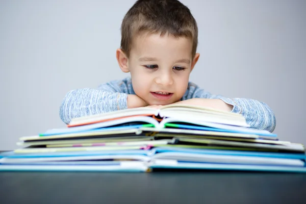 Liten pojke läser en bok — Stockfoto