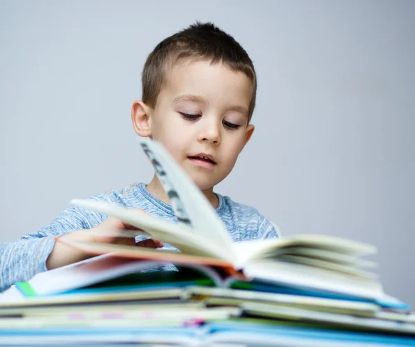 Liten pojke läser en bok — Stockfoto