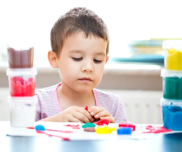 Junge spielt mit Farbspielteig — Stockfoto