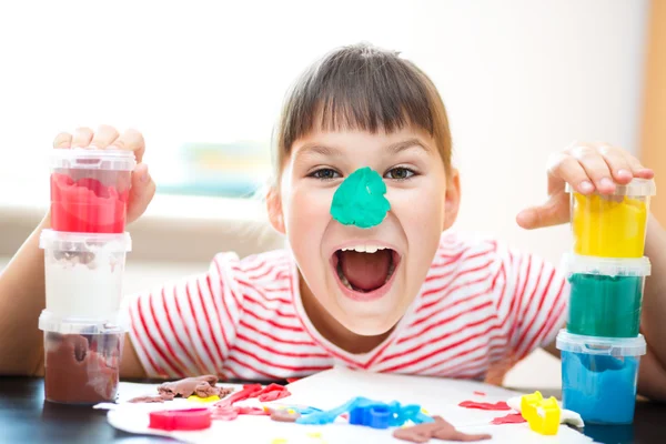 Девушка играет с цветом тесто — стоковое фото