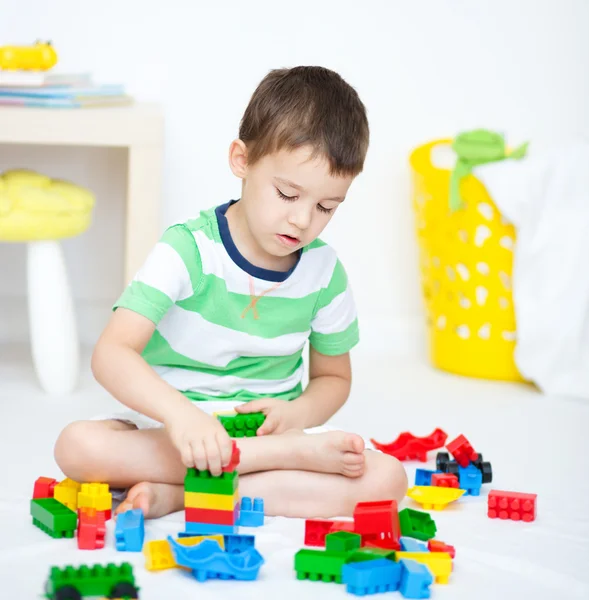 Chico está jugando con bloques de construcción —  Fotos de Stock