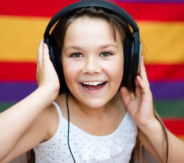 Chica está disfrutando de la música usando auriculares — Foto de Stock