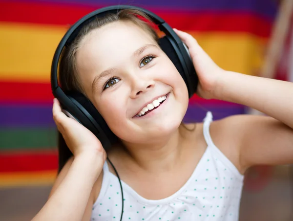 Chica está disfrutando de la música usando auriculares —  Fotos de Stock