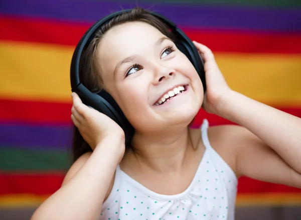 Chica está disfrutando de la música usando auriculares —  Fotos de Stock