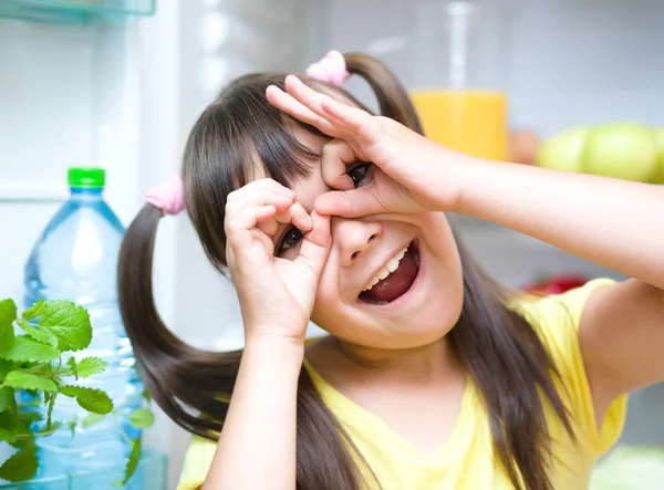 Mädchen steht neben Kühlschrank — Stockfoto