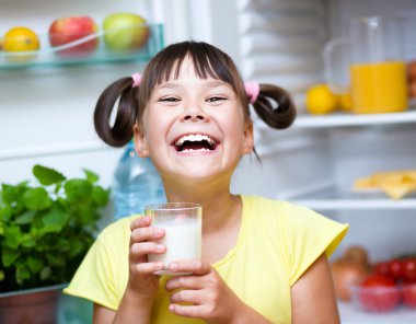 Kız içki süt ayakta buzdolabı yakınındaki