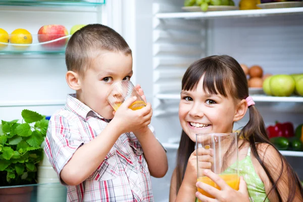 子供は冷蔵庫近く立ち飲みジュース — ストック写真