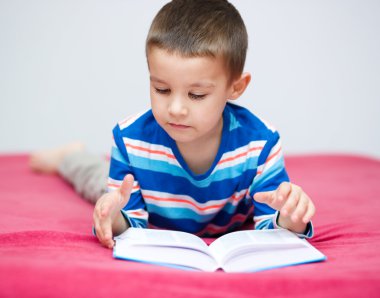 küçük çocuk bir kitap okuma