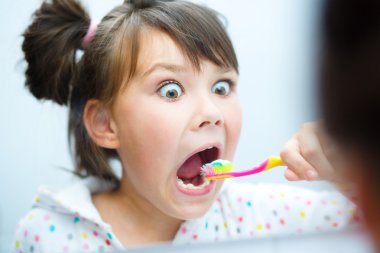Girl brushes her teeth clipart