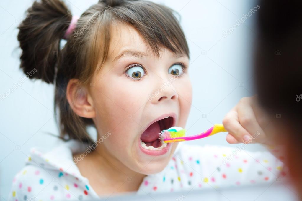 Girl brushes her teeth