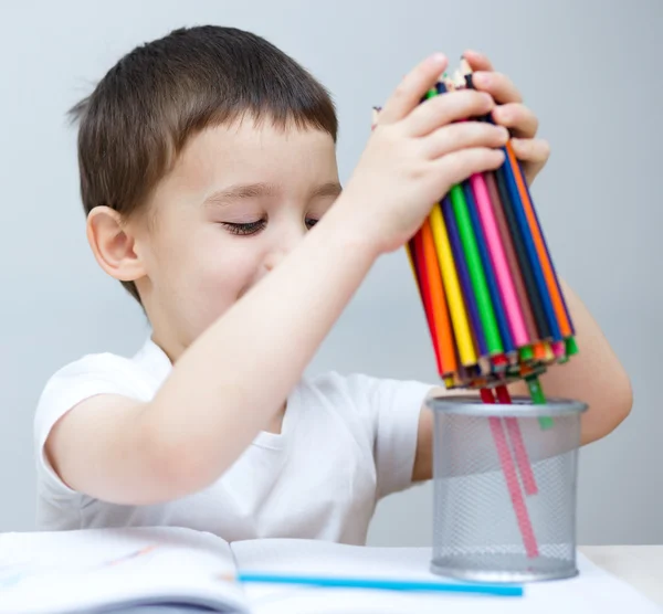 Menino está segurando lápis de cor — Fotografia de Stock