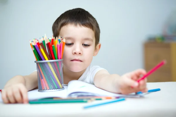 Kleiner Junge hält Farbstifte in der Hand — Stockfoto