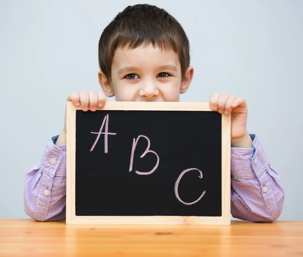 Schattige jongen houdt schoolbord — Stockfoto