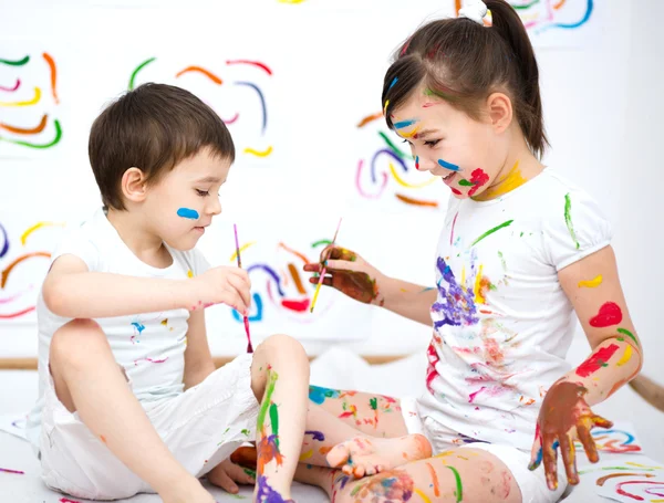 Mignon garçon et fille jouer avec des peintures — Photo