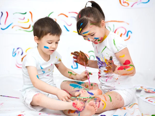 Mignon garçon et fille jouer avec des peintures — Photo