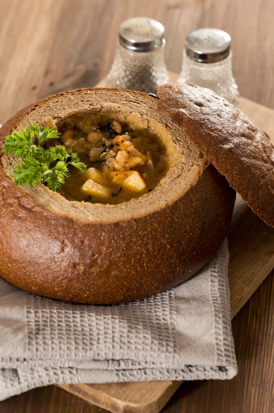 Fresh pea soup in bread bowl on a wooden desck — Stock Image Fresh pea soup in bread bowl on a wooden desck Stock Photo
