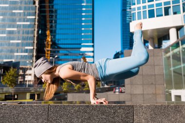 Genç kız açık havada şehirde yoga yaparken
