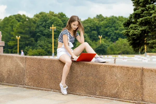 Молода жінка з ноутбуком сидить на сходах біля університету — стокове фото