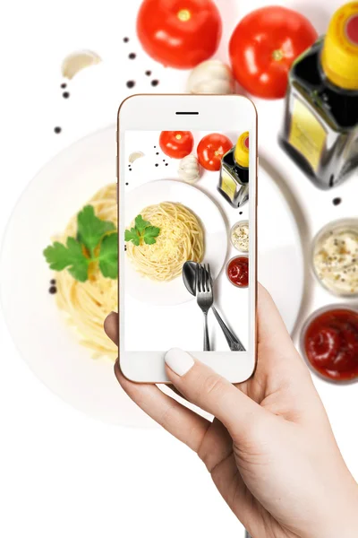 Femme photographiant sur smartphone, plaque de spaghetti de cuisine avec des légumes — Photo