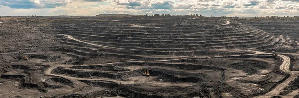 Panoramic aerial view of coal mine. Open pit mine industry, big yellow mining truck for coal quarry. Open coal mining anthracite mining. Pit on coal mining by open way. Rock loading in trucks