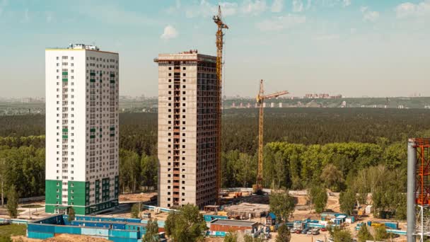 Canteiro de obras com guindaste grande torre em lapso de tempo sob conceito de construção. Timelapse of Large Real Estate Construction Site with Multiple operating Tower Cranes (em inglês). Máquinas pesadas para construção — Vídeo de Stock