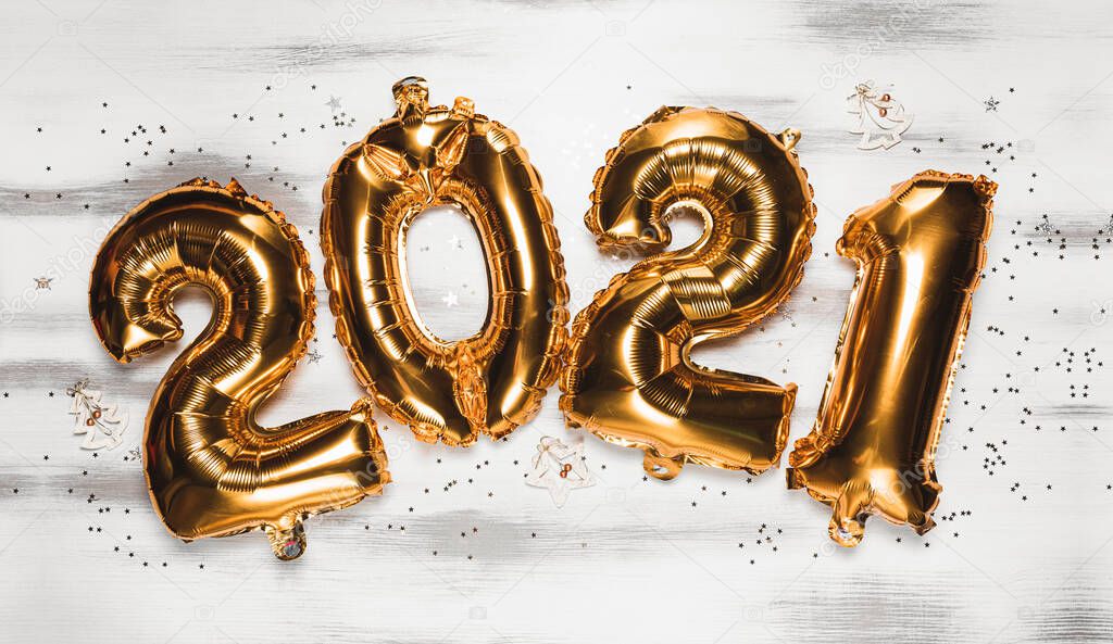 Happy New year 2021 celebration. Bright gold balloons figures New Year Balloons with glitter stars on white background. Christmas and new year celebration. Gold foil balloons numeral 2021 and confetti