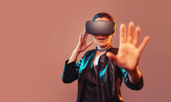 Ragazza ottenere esperienza VR auricolare sta utilizzando occhiali realtà aumentata di essere in realtà virtuale. Ragazza con le mani alzate indossando occhiali di realtà virtuale. Donna che tocca aria durante l'esperienza VR — Foto Stock