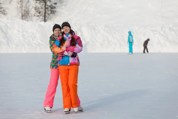 Young people, friends, winter ice-skating on the frozen lake — Stock fotografie