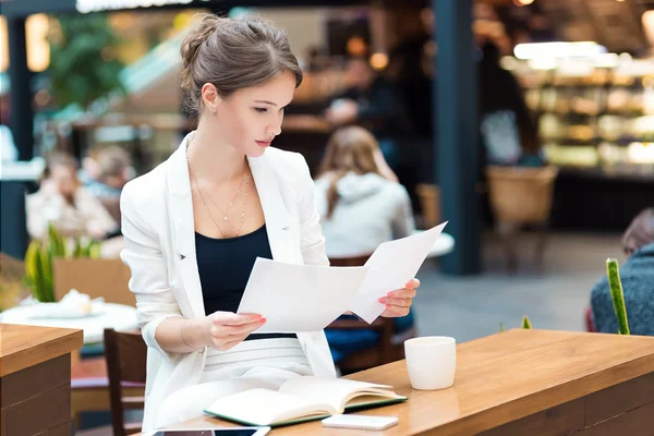 Молодая, красивая девушка в белом костюме, сидящая в кафе — стоковое фото