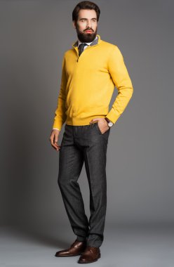 Genç adam bir sakal ve bir jersey ve ayakta pantolon,