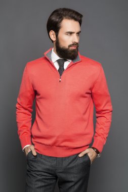 Genç adam bir sakal ve bir jersey ve ayakta pantolon,