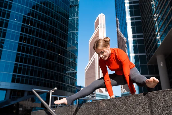 Genç kız açık havada şehirde yoga yaparken