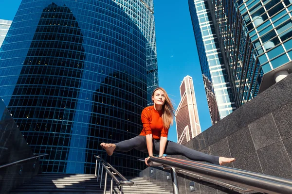 Genç kız açık havada şehirde yoga yaparken