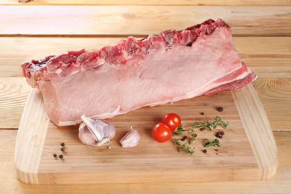 Raw meat pork fillet on ribs on a wooden board — Stock Photo, Image