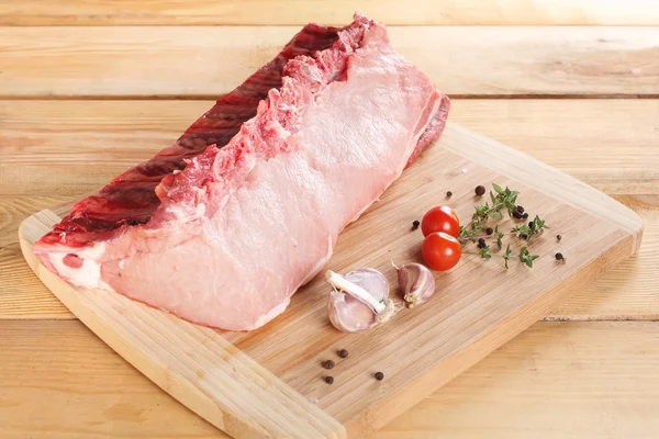 Raw meat pork fillet on ribs on a wooden board — Stock Photo, Image