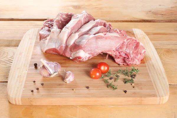 Raw meat pork steaks on the bone on a wooden board — Stock Photo, Image