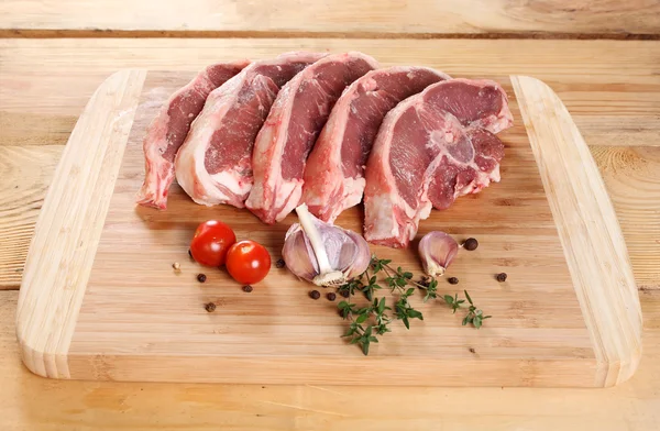 Raw meat lamb entrecote on bone on a wooden board — Stock Photo, Image