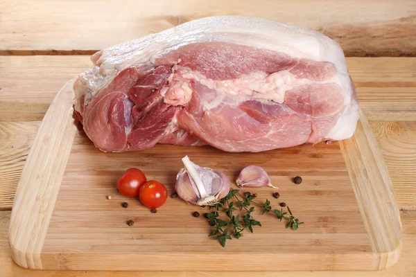 Raw meat, pork, ham on the bone, on a wooden board — Stock Photo, Image