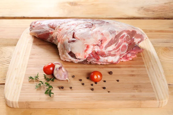 Surowe mięso, Baranka. Tylne nogi szynka na drewnianej desce — Zdjęcie stockowe