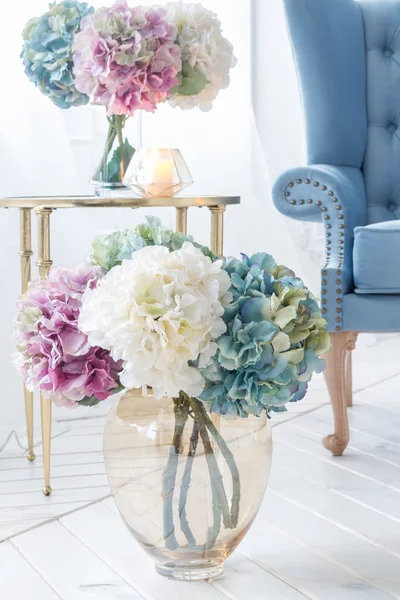 Blumen neben blauem Sofa — Stockfoto