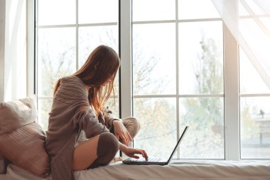 Bir pencere üzerinde oturan güzel genç kadın