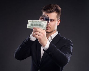 İş adamı büyüteçle bakıyor